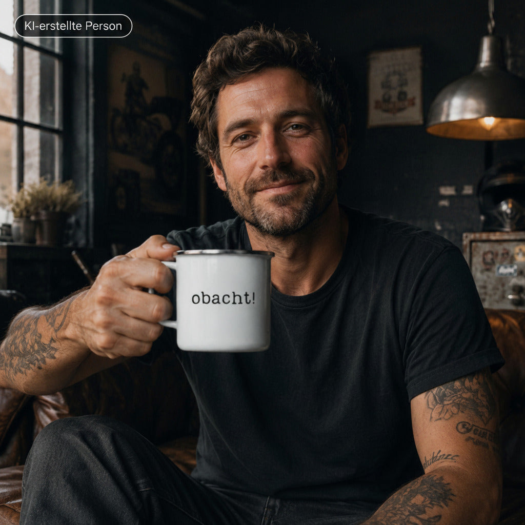 Emaille Tasse mit dem Aufdruck "obacht", ein Mann hält sie in die Kamera